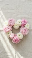 Pink and white ranunculus flowers arranged in heart shape on linen fabric for romantic wedding decoration and love celebration concepts.