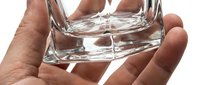Hand holding clear glass cup filled with water against white background, suitable for beverage, hydration, wellness and lifestyle design projects.