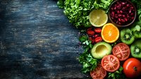 Fresh colorful fruits and vegetables arranged on dark rustic wooden background with copy space. Healthy eating ingredients for salad or smoothie making.
