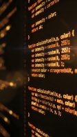 Programming code on computer screen with orange syntax highlighting showing functions and variables for software development and web programming projects.