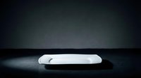 White ceramic plate on dark surface with moody lighting, suitable for food photography, restaurant menus, culinary blogs, and tableware design projects.