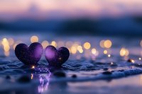 Two purple glittery hearts on wet surface with bokeh lights creating romantic atmosphere for Valentine's Day, wedding or love concept backgrounds.