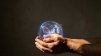 Elderly hands holding glowing crystal ball with mystical energy and lightning effects against dark background for fortune telling and magic concepts.