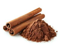 Cinnamon sticks and ground cinnamon powder isolated on white background for culinary and baking applications.