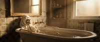 Skeleton soaking in vintage bathtub with warm lighting, perfect for horror, Halloween, gothic themes, and creative editorial projects.