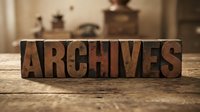 Vintage wooden letterpress blocks spelling ARCHIVES on rustic table, antique typography for historical research, library organization and document storage.