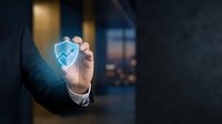 Businessman hand holding glowing digital house icon with upward arrow symbolizing real estate growth and property investment success in modern office.