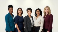 Young diverse women professionals standing together in business casual attire against neutral background, representing teamwork, diversity and corporate workforce for business and corporate communications.