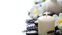 Spa wellness composition with burning candle, lavender flowers, plumeria blossoms and smooth stones on white background for relaxation and aromatherapy.