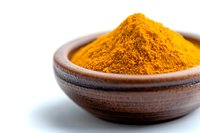 Ground turmeric powder in traditional wooden bowl on white background. Bright yellow-orange spice used in Asian cuisine and natural medicine.