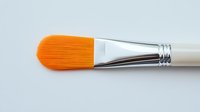 Professional art brush with bright orange synthetic bristles and white handle featuring chrome metal ferrule on neutral background for creative projects and painting supplies.