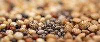 Mixed variety of raw legumes beans lentils and pulses scattered creating natural organic food background texture for healthy cooking and nutrition concepts.