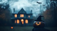 Spooky Halloween scene with glowing jack o'lantern wearing witch hat in foreground, haunted house with lit windows and flying bats against misty twilight sky.