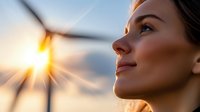 Young woman gazing at wind turbine during golden sunset, profile view capturing hopeful expression and natural lighting, representing clean energy future.
