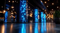 Modern interior with glowing blue LED columns and warm pendant lights reflecting on glossy floor, creating dramatic nightclub or event space atmosphere.