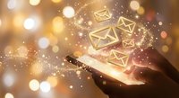 Digital communication concept with glowing email icons floating above smartphone in hand against warm bokeh background for marketing campaigns.