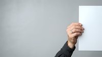 Caucasian male hand holding blank white paper or card against neutral gray background, suitable for advertising, marketing campaigns, presentations, and promotional materials.