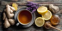 Herbal tea with ginger, lemon, honey and lavender on rustic wooden background, natural remedy for cold and flu season.