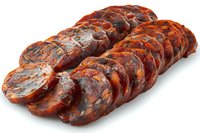 Sliced Spanish chorizo sausage with red paprika coating arranged in rows on white background, traditional cured meat delicacy isolated for culinary design.