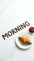 Morning word made of coffee beans beside a croissant on white plate and raspberry jam on marble surface, top view breakfast concept.
