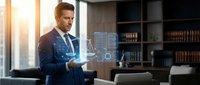 Professional businessman in suit using holographic digital interface technology in modern office environment for business innovation and data analysis.
