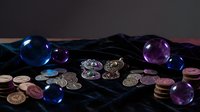 Fortune teller mystical setup with crystal balls, ancient coins and dark velvet cloth for divination and spiritual guidance sessions.