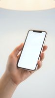 Hand holding smartphone with blank white screen mockup for app presentation and mobile interface design on neutral background.