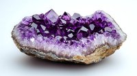 Purple amethyst crystal geode formation showing deep violet crystals and natural raw edges, with gradual color transition from dark to light, set against white background.