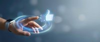 Hand holding glowing thumbs up like icon with circular light effects on blurred background representing social media engagement and digital approval.