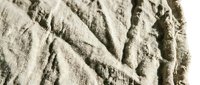 Crumpled beige linen fabric with natural wrinkles and folds, suitable for textile, fashion, and interior design projects.