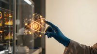 Scientist in lab coat and gloves holding glowing atom model symbol, representing nuclear physics, atomic energy research, and scientific innovation in modern laboratory setting.