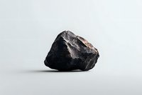 Raw black stone mineral specimen isolated on white background, showing natural texture and rough surface detail for geology, mining and mineral collection purposes.