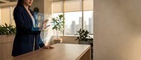 Professional businesswoman using holographic technology interface in modern office environment with city skyline view and natural lighting.