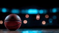 Basketball on dark reflective surface with blurred bokeh lights in background creating dramatic sports atmosphere. Professional equipment for game and competition.
