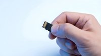 Small memory card held in hand against white background, isolated for design use on technology websites, educational materials, and digital storage product presentations.