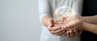 Hands holding a glowing holographic brain symbol, representing neuroscience, mental health awareness, and cognitive research in healthcare.