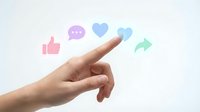 Hand pointing at floating social media icons including thumbs up, chat bubble, heart and arrow on white background for digital marketing concepts.