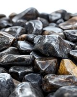 Smooth polished black and brown river rocks with glossy surface texture, natural stone background for zen gardens, landscaping, or spa decor.