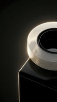 Modern white ceramic coffee cup on black surface with dramatic rim lighting creating elegant shadows and highlights for luxury beverage branding.