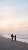 Elderly couple holding hands walking on beach at sunset with pastel sky and ocean waves creating romantic silhouette scene for love and retirement concepts.