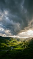 Dramatic stormy sky looms over lush green valley with winding river and rolling hills, perfect for travel, nature, and landscape design projects.