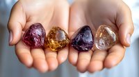 Female hands holding colorful healing crystals and gemstones including amethyst, citrine and clear quartz against soft neutral background for spiritual wellness.