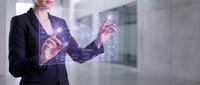 Young woman in business attire interacting with holographic digital interface displaying data visualization and technology icons in modern office environment.
