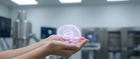 Scientist hand holding glowing pink holographic brain in modern laboratory setting, representing artificial intelligence, neuroscience research, and digital innovation technology.