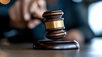 Wooden judge gavel on sound block with blurred courtroom background for legal proceedings and justice system concepts.