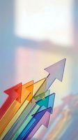 Colorful transparent glass arrows pointing upward on soft gradient background representing growth, success, progress and business development concepts.