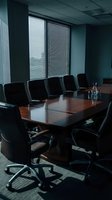 Modern corporate boardroom with dark wood conference table and black leather executive chairs for business meetings and professional presentations.