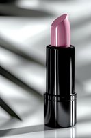 Pink lipstick in black glossy tube against soft white background with shadow play, elegant cosmetic product photography for beauty and makeup advertising.
