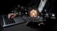 Real estate technology concept with businessman using laptop displaying digital property analytics, charts, and home icon for modern property investment solutions.