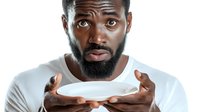 Young African male with beard wearing white t-shirt, expressing confusion or uncertainty with open palms raised, isolated on white background for advertising and commercial use.